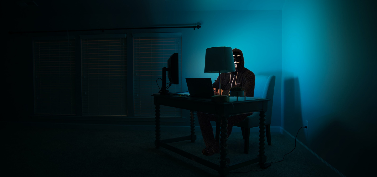Человек в маске за компьютером
